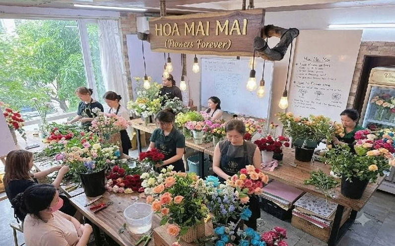 Không gian xưởng hoa rộng rãi, nơi các nghệ nhân đang tỉ mỉ tạo nên những mẫu hoa tươi. 